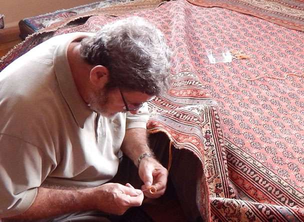 Man sewing the rug